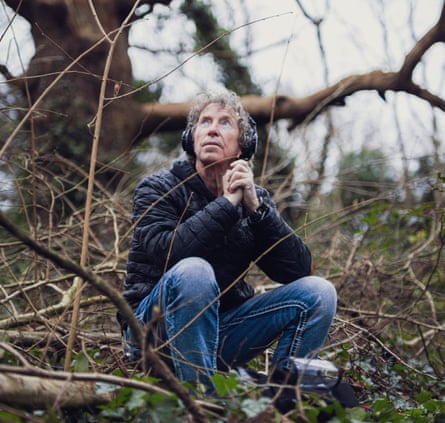 Martyn Stewart sits on the ground surrounded by branches and twigs