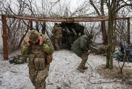 Three soldiers in camouflage fatigues fire a heavy field gun in a snowy landscape