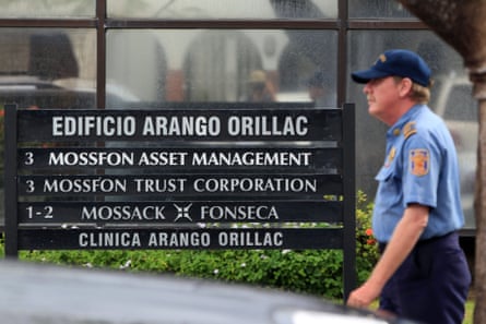 A security guard outside offices with signs in Spanish