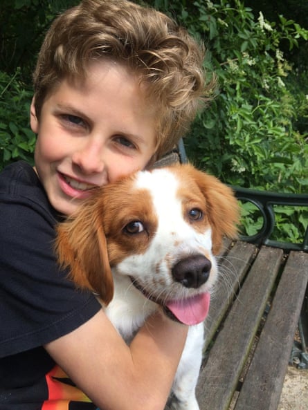 Isaac Kenevan with his arms around a dog