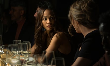 A woman with long brown hair looks concerned at a dinner table