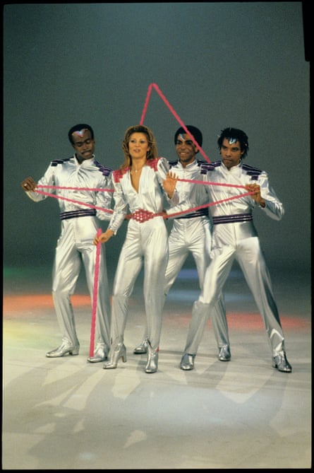 Sheila B & B Devotion with two dancers, dressed in silver one-piece suits a bit like Mork in Mork and Mindy.