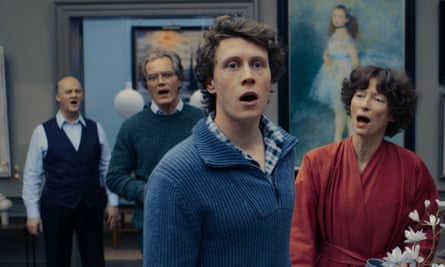 A screengrab showing Tim McInnerny, Michael Shannon, George MacKay and Tilda Swinton standing in a room of a house and singing