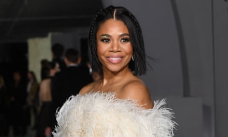 a woman wearing a feathery white dress smiles and looks over her shoulder