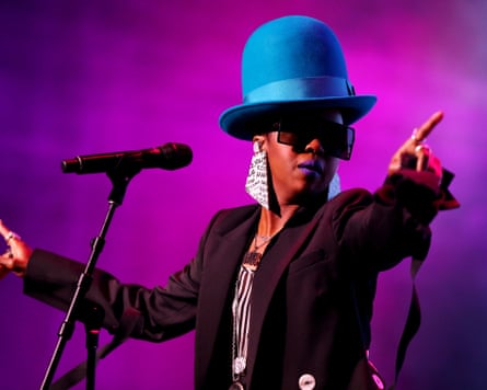 Lauryn Hill performing in Sydney, Australia, in 2019, wearing a large blue hat and big sunglasses and earrings.