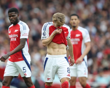 Martin Ødegaard wipes his face with his Arsenal shirt